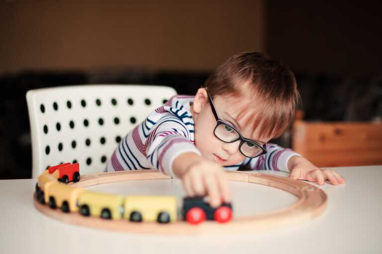 special needs child playing with train
