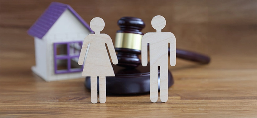 Wooden figures of man and woman standing on table near gavel