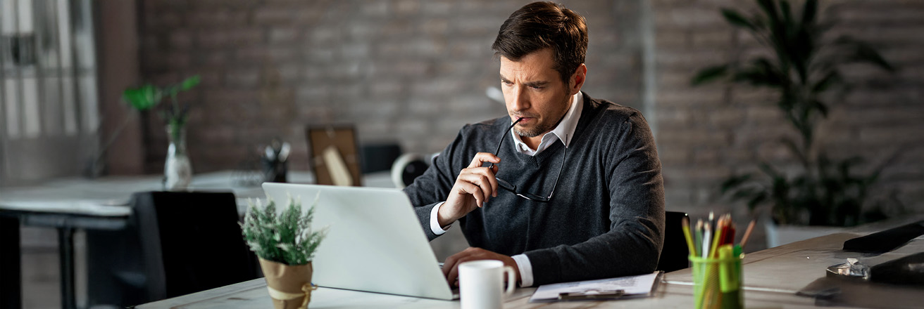 Worried male entrepreneur working on a computer in the office
