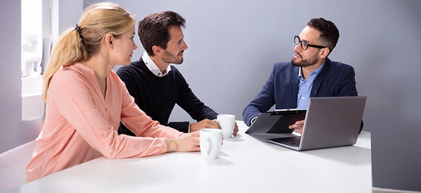 Young Couple Consulting Male Friendly Financial Advisor