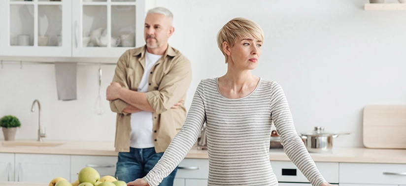 man and woman ignore each other in kitchen