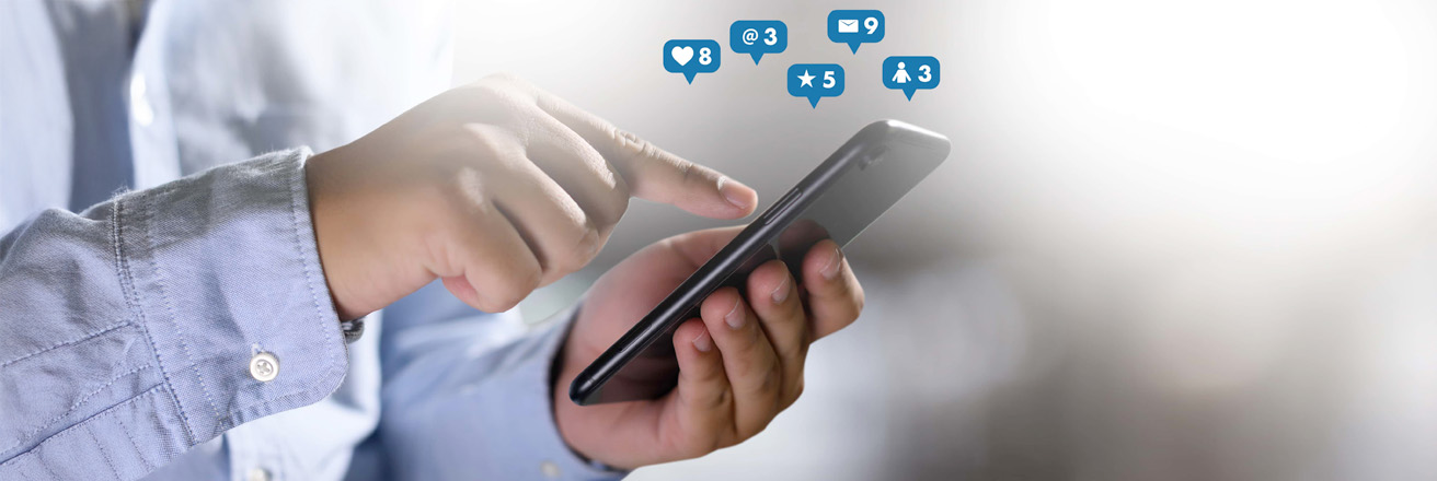 man on his phone with social icons floating over the top