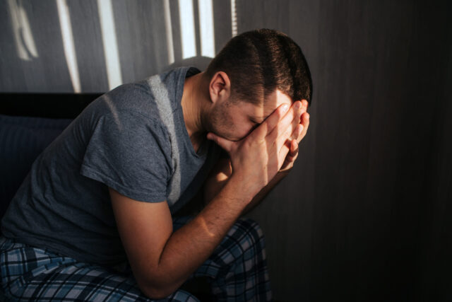 sad man with hands in face sitting