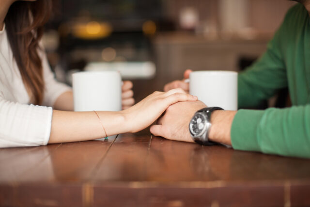 Holding hands at a coffee shop